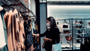 female looking at clothes in retail store wearing mask