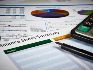 balance-sheet-paperwork-on-desk-with-pen-and-calculator-feature-image-in-off-balance-sheet-financing-blog