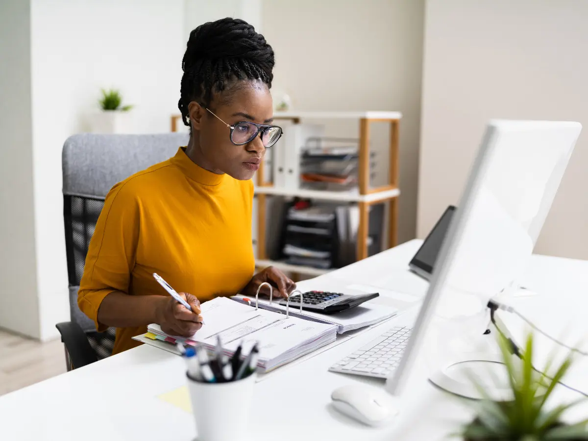 lady-at-desk-looking-at-paperwork-with-calculator-main-feature-image-off-balance-sheet-financing-blog